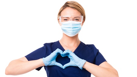 Healthcare worker wearing a mask and making a heart with her hands